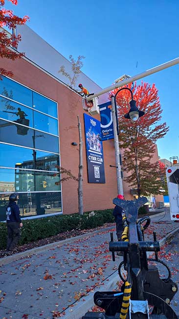 Tree pruning crew working near the chipper and truck beside the arena entrance